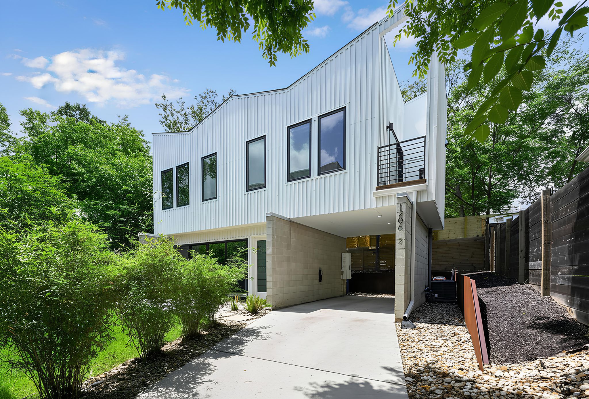 1206 Luna Street, Unit 2 Austin, TX 78721 - Photo 9 of 30 The property features a contemporary architectural style with white corrugated siding and black-framed windows