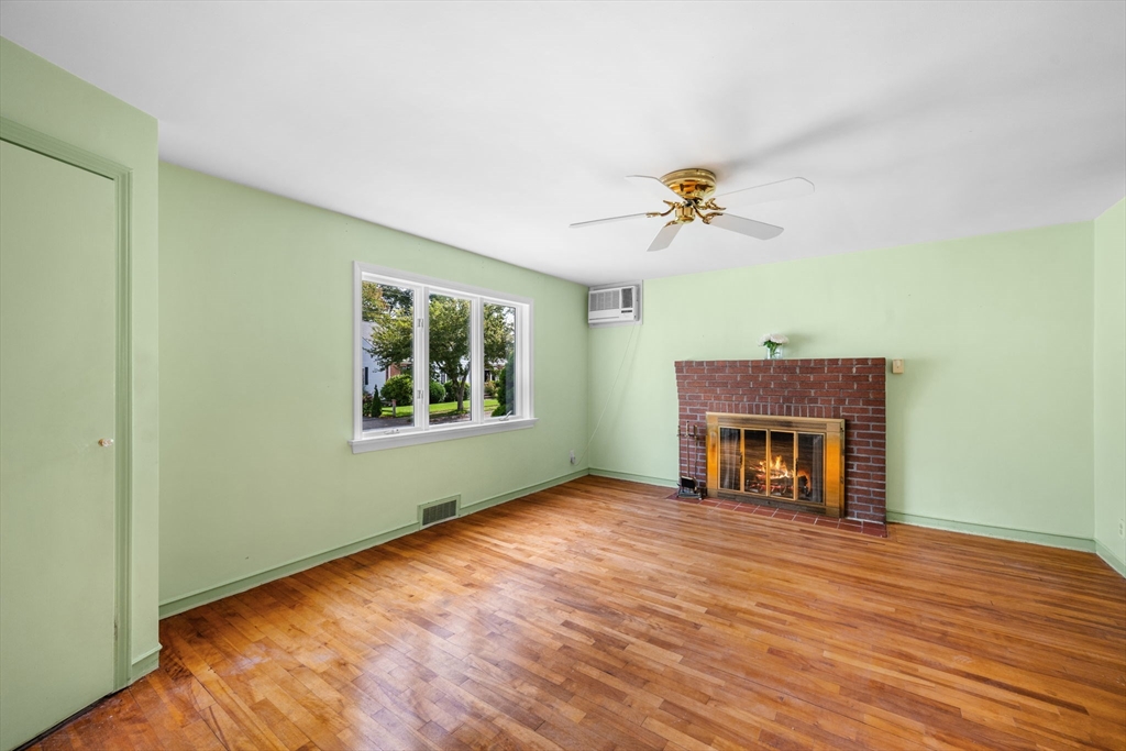 11 May Street Marblehead, MA 01945 - Photo 4 of 22 an empty room with windows fireplace and a wooden floor