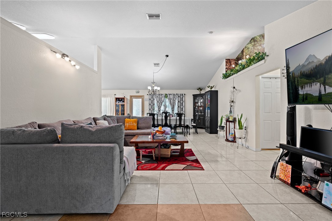 609 Gerald Avenue Lehigh Acres, FL 33936 - Photo 12 of 45 a living room with furniture and a flat screen tv