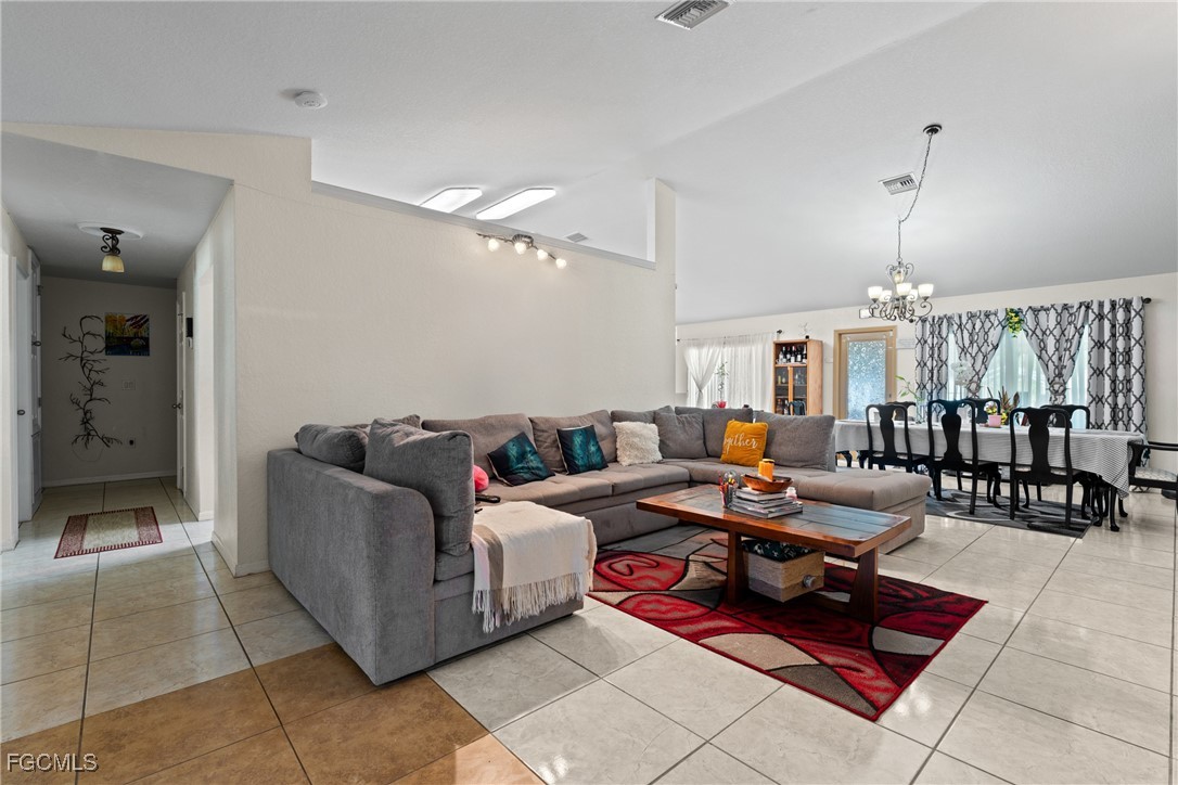 609 Gerald Avenue Lehigh Acres, FL 33936 - Photo 13 of 45 a living room with furniture a dining table and chairs with the view of kitchen