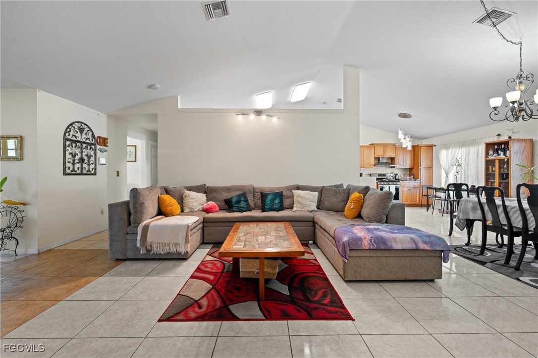 609 Gerald Avenue Lehigh Acres, FL 33936 - Photo 14 of 45 a living room with furniture a rug and gym equipment