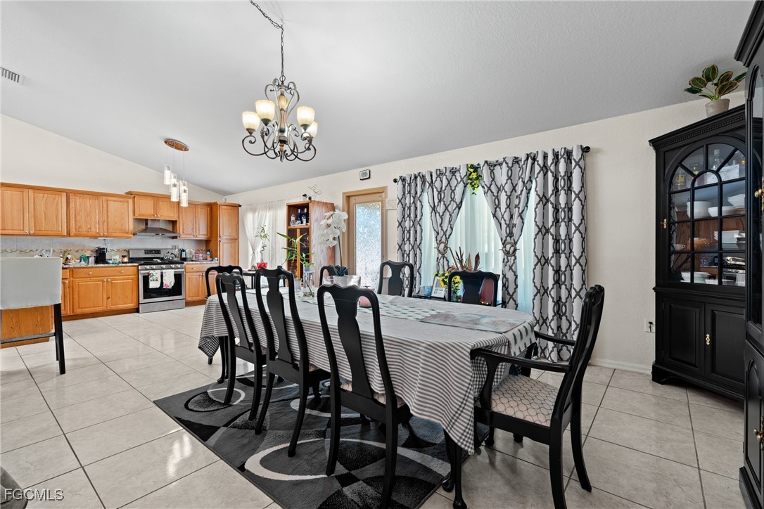 609 Gerald Avenue Lehigh Acres, FL 33936 - Photo 15 of 45 a view of a dining room with furniture and a chandelier