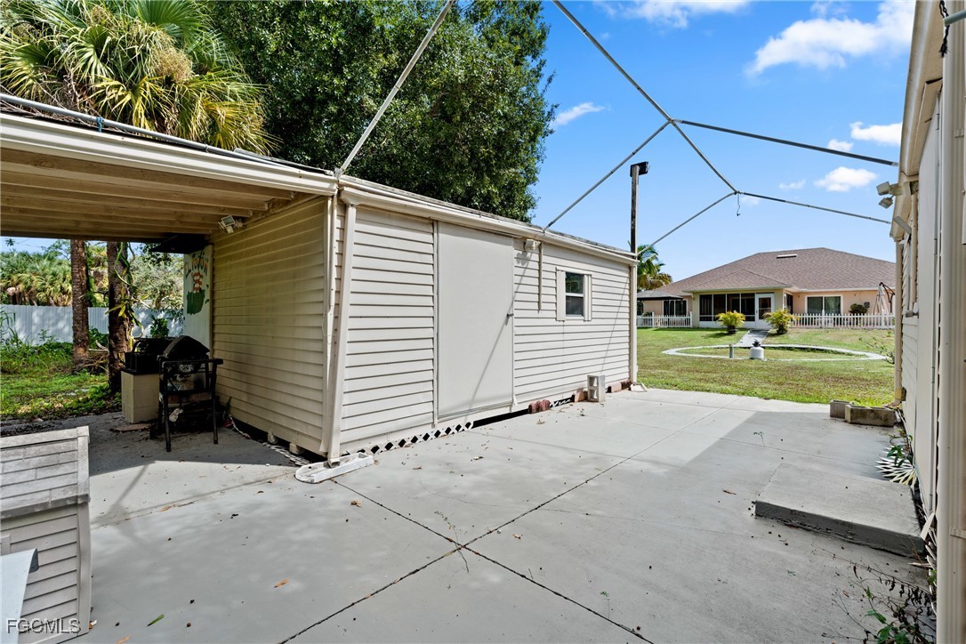 609 Gerald Avenue Lehigh Acres, FL 33936 - Photo 32 of 45 a view of a patio with a table and chairs under an umbrella