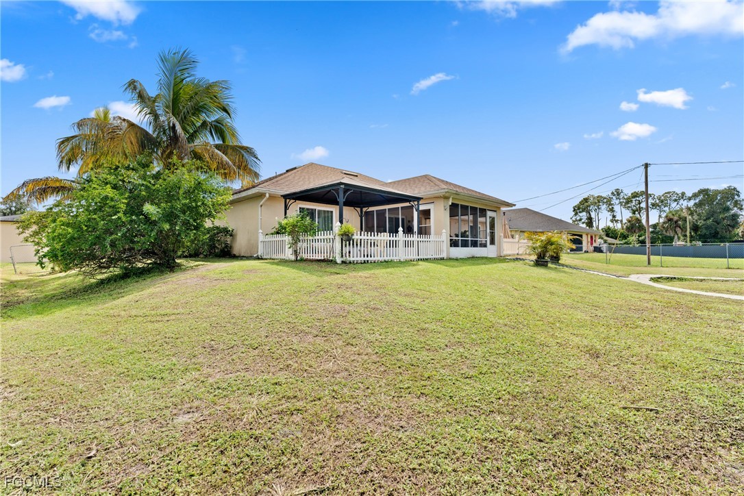 609 Gerald Avenue Lehigh Acres, FL 33936 - Photo 34 of 45 a front view of a house with a garden