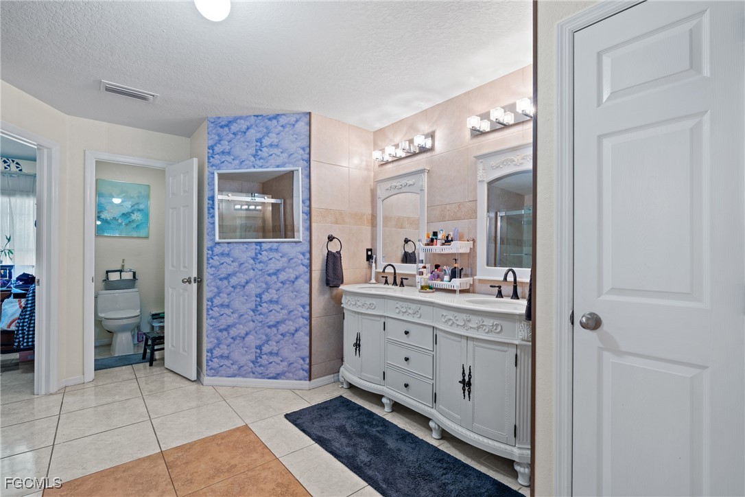 609 Gerald Avenue Lehigh Acres, FL 33936 - Photo 38 of 45 a bathroom with a granite countertop sink a mirror and a