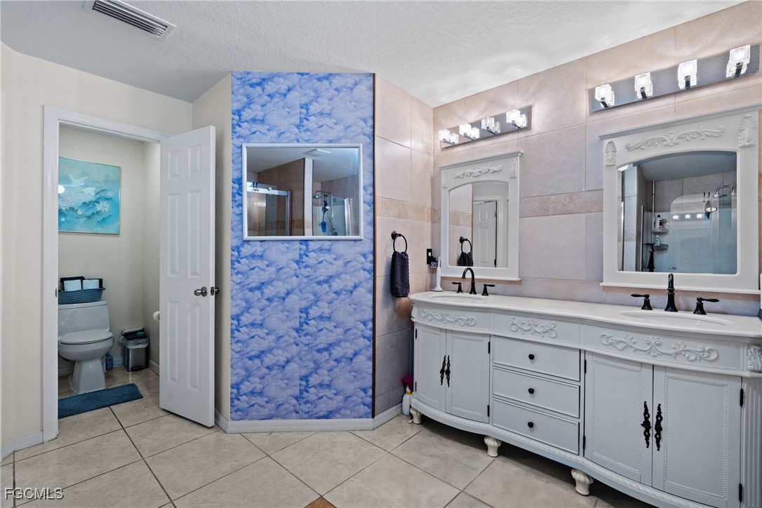609 Gerald Avenue Lehigh Acres, FL 33936 - Photo 40 of 45 a bathroom with a double vanity sink and a mirror