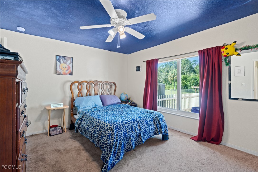 609 Gerald Avenue Lehigh Acres, FL 33936 - Photo 41 of 45 a bedroom with a bed and a chandelier