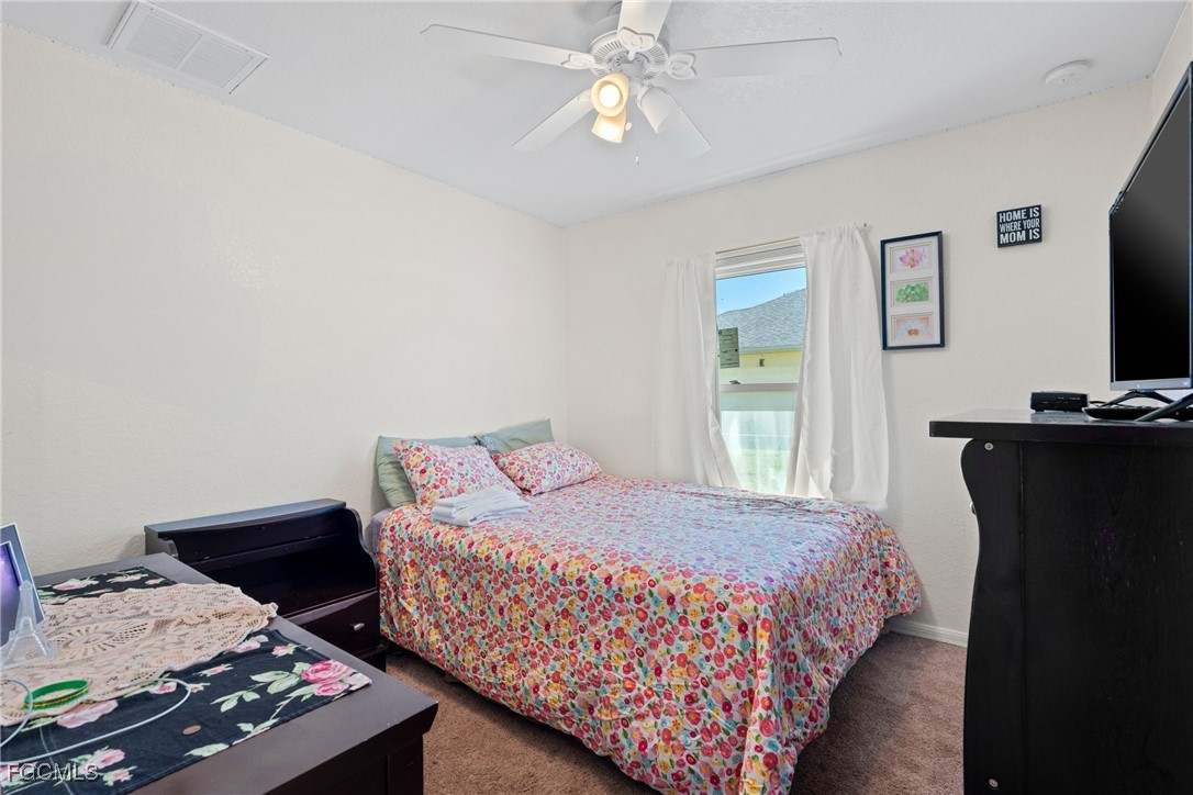 609 Gerald Avenue Lehigh Acres, FL 33936 - Photo 43 of 45 a bedroom with a bed and a flat screen tv