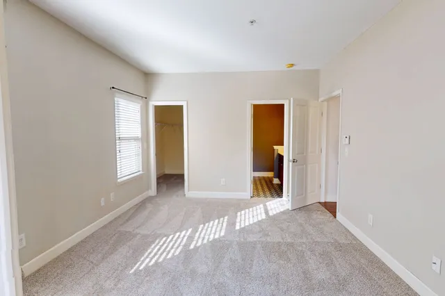 a view of an empty room with closet and a window