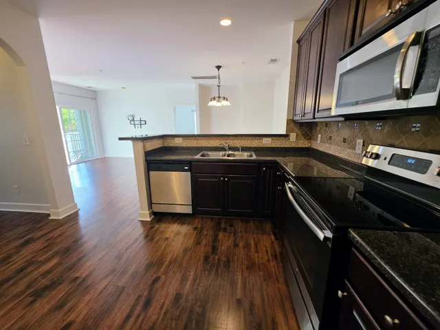 a kitchen with wooden floors and appliances