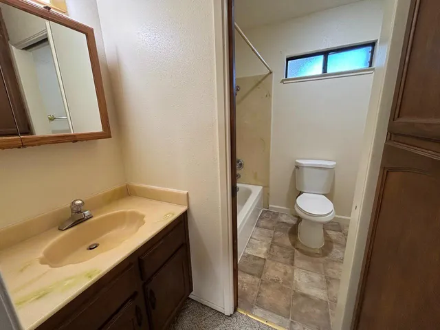 a bathroom with a sink a toilet and mirror