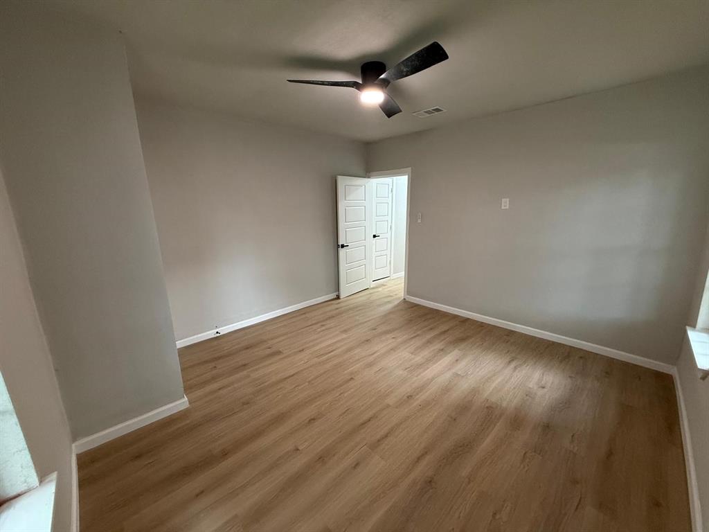 758 Bethpage Avenue Dallas, TX 75217 - Photo 17 of 20 an empty room with wooden floor and windows