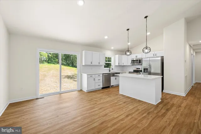 a kitchen with cabinets stainless steel appliances a sink and a window