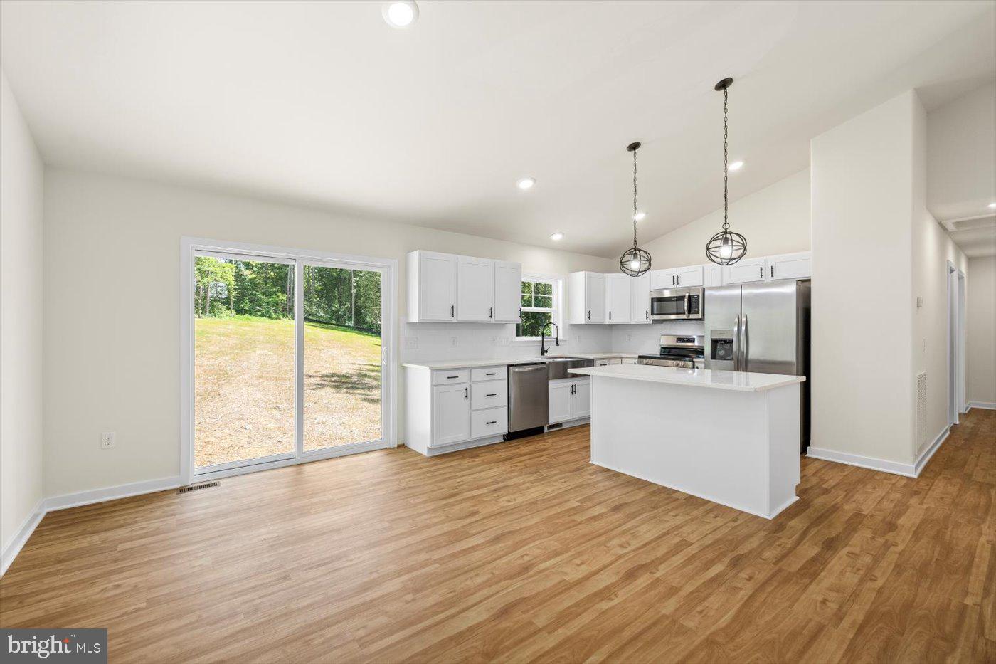 3319 Partlow Road Partlow, VA 22534 - Photo 15 of 47 a kitchen with stainless steel appliances kitchen island wooden floors and white cabinets
