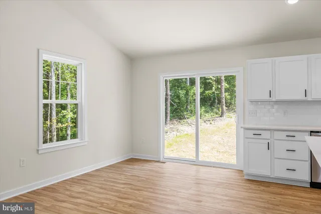 a kitchen with stainless steel appliances granite countertop a sink dishwasher a refrigerator and a stove with wooden floor