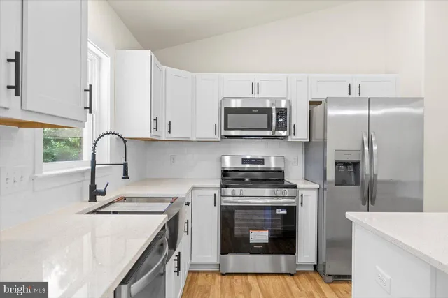 a view of kitchen with sink and refrigerator