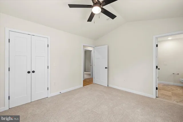 a view of a big room with windows and chandelier fan