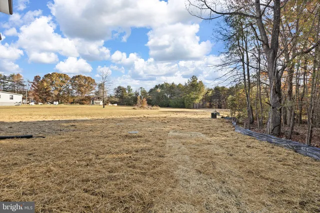 a view of a yard with wooden fence