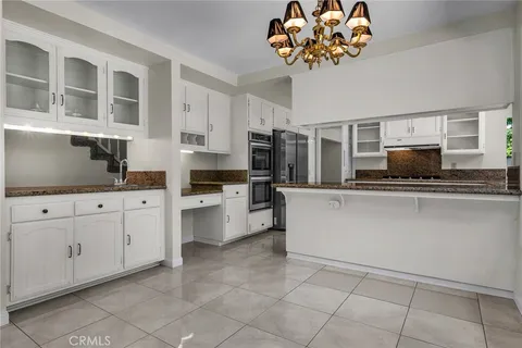 a kitchen with stainless steel appliances granite countertop a refrigerator sink and cabinets