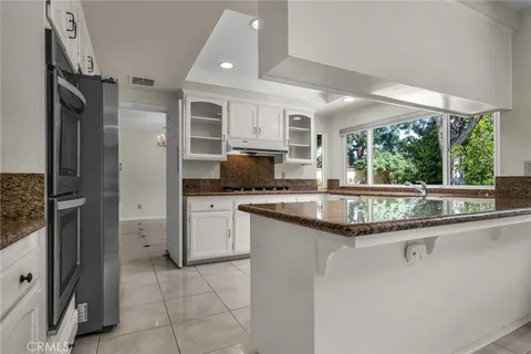 a kitchen with stainless steel appliances granite countertop a sink and a refrigerator