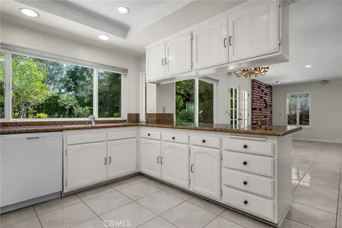 a kitchen with cabinets appliances and a large window