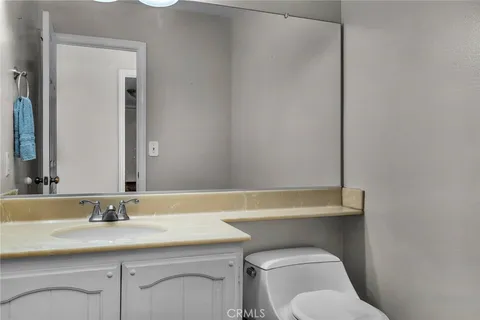 a bathroom with a granite countertop toilet sink and mirror
