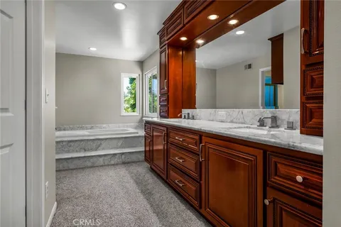 a bathroom with a tub sink and mirror