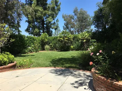 a view of a garden with flowers and trees