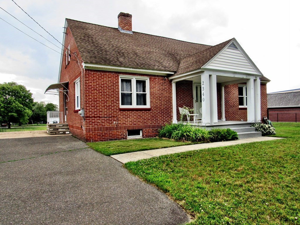 2340 Main Street Three Rivers, MA 01080 - Photo 3 of 31 a front view of a house with a yard and garage