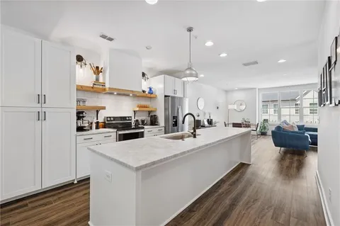 a kitchen with a sink a counter top space and stainless steel appliances