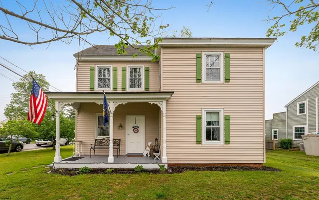 a front view of a house with a garden and trees