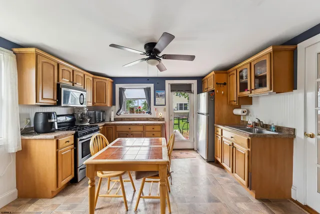 a kitchen with a table chairs refrigerator and cabinets