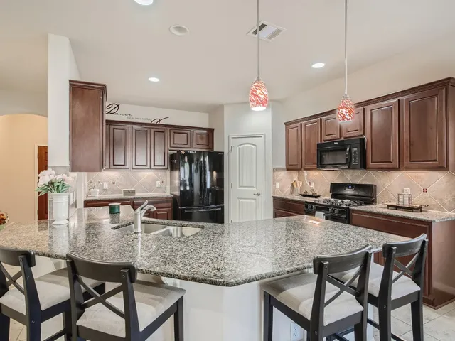 a kitchen with kitchen island granite countertop a table and chairs in it