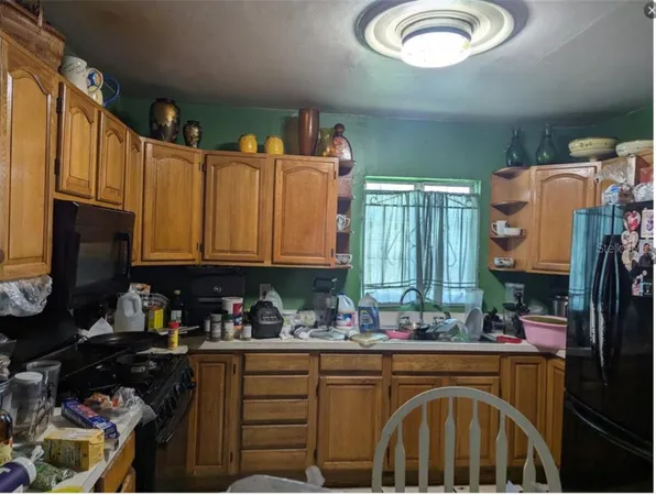 a kitchen with granite countertop a refrigerator and a sink