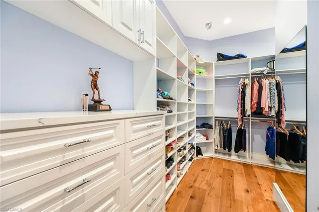 a view of walk in closet with clothes and shoes