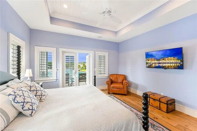 a view of a dining room with furniture one side kitchen view and wooden floor