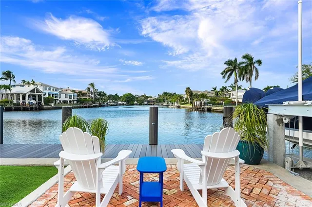 a patio with a table and chairs plants and swimming pool