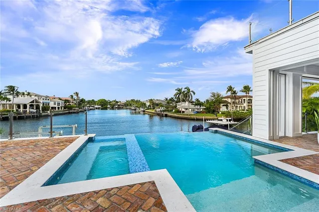 a view of a swimming pool with a lounge chair and a lake view