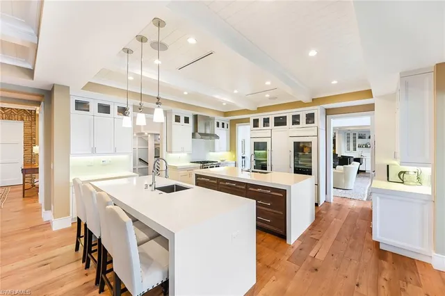 a large kitchen with kitchen island a stove a sink a dining table and chairs