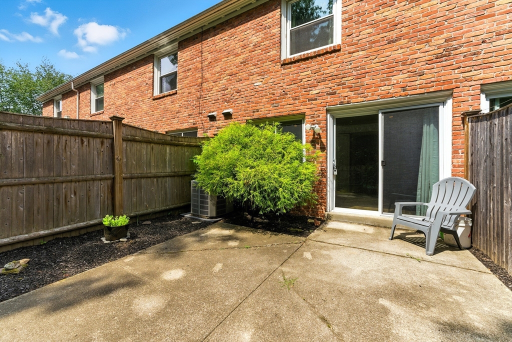 73 Yorktown Drive, Unit 73 Springfield, MA 01108 - Photo 26 of 42 a view of backyard with chair and table in the patio