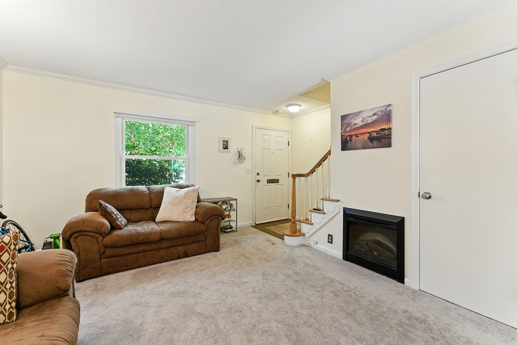 73 Yorktown Drive, Unit 73 Springfield, MA 01108 - Photo 5 of 42 a living room with furniture a window and a fireplace