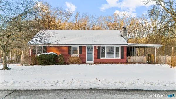 a front view of house with yard covered in snow
