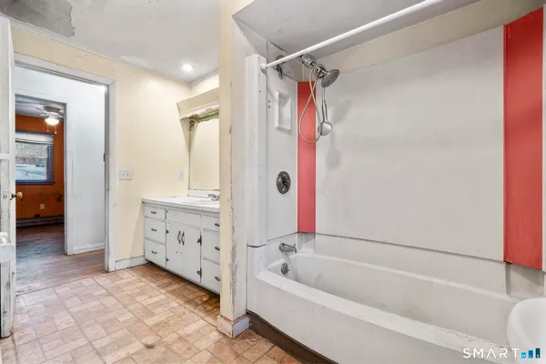 a bathroom with a tub a sink and a large mirror
