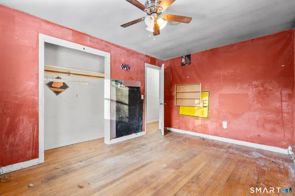 a view of a livingroom with a chandelier fan and a window