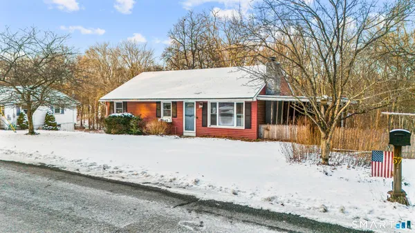a front view of a house with a yard covered with snow