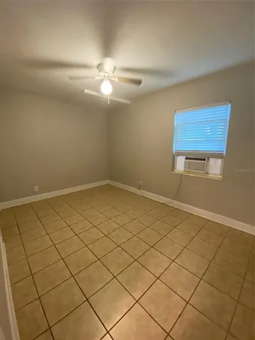 an empty room with a chandelier fan