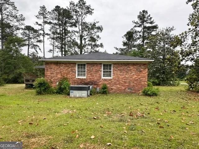 a backyard of a house with plants and tree
