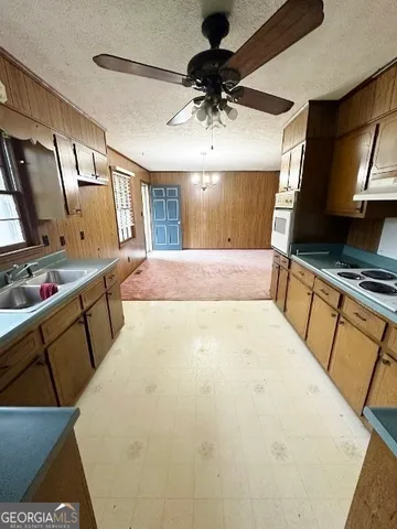 a spacious bedroom with a bed a flat screen tv and dresser