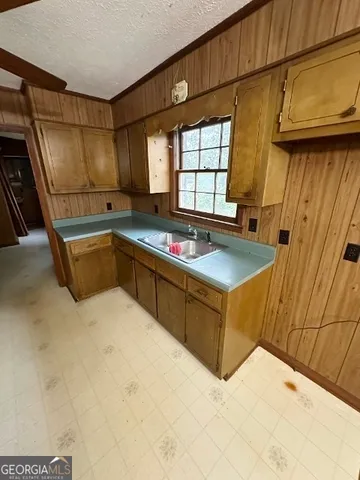 a kitchen with granite countertop a sink and a refrigerator