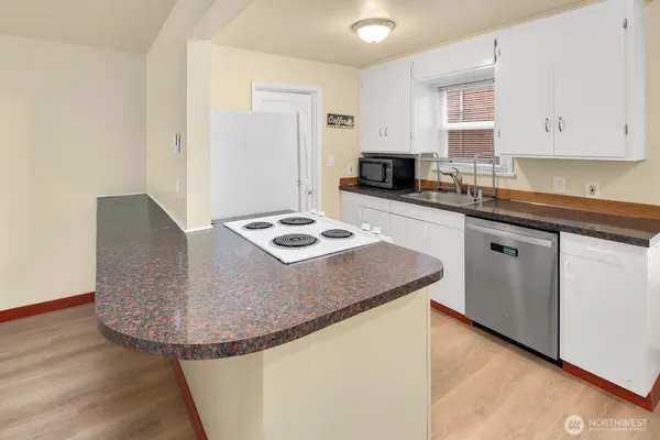 a kitchen with granite countertop a stove and a sink